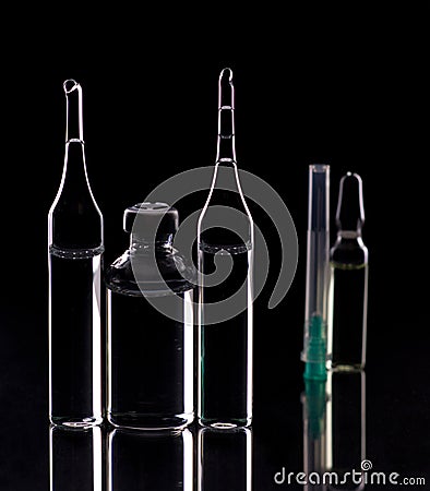 Glass ampoules close up. Medical ampoules. Medical ampoules, syringe needle on a black background Stock Photo