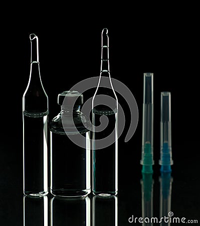 Glass ampoules close up. Medical ampoules. Medical ampoules, syringe needles on a black background Stock Photo