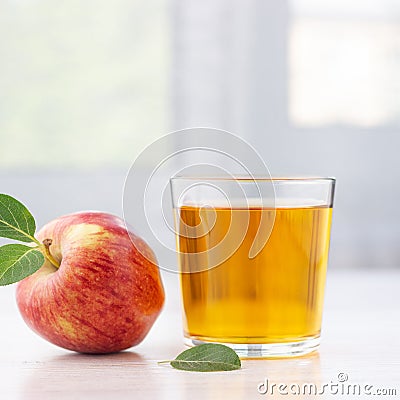 Glass of apple juice and ripe red apples with leaves. Stock Photo