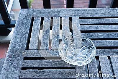 Glass Ashtray on Wooden Table. Stock Photo