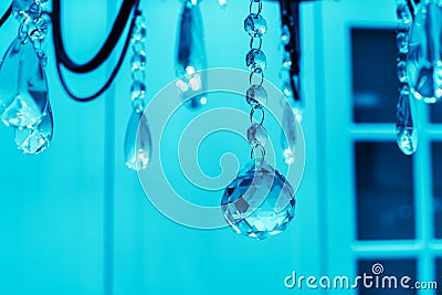 Glass balls on a metal chain. Decorating a chandelier with crystal pendant products. Tinted photo. Cold shades Stock Photo