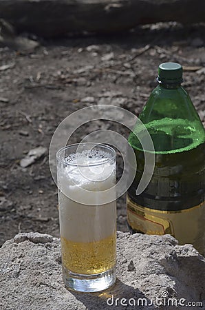 Glass glass with beer and foam on top of stone outside Stock Photo