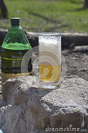 Glass glass with beer and foam on top of stone outside Stock Photo
