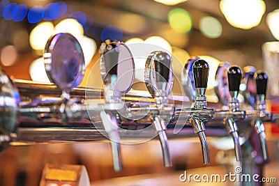 Glass of beer in pub, hand of bartender pouring a large lager beer in tap, the beer taps in a pub. Stock Photo