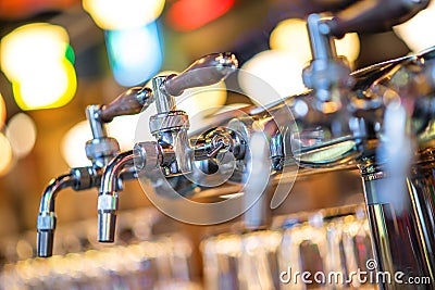 Glass of beer in pub, hand of bartender pouring a large lager beer in tap, the beer taps in a pub. Stock Photo