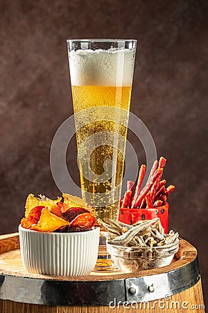 glass of beer with snacks. Dried fish mix on wood plate. dried fish chorizo sausage meat carpaccio Stock Photo