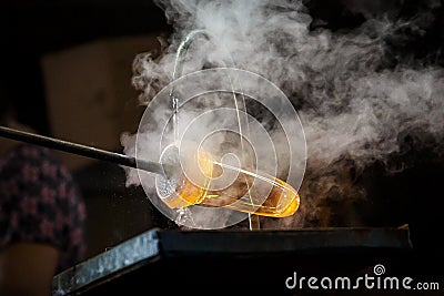 Glass blower forming piece of glass, water cooling. Stock Photo