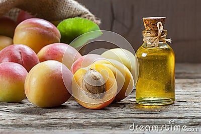 Glass bottle of Apricot seed kernel oil prunus armeniaca oleum with fresh ripe apricot fruits Stock Photo