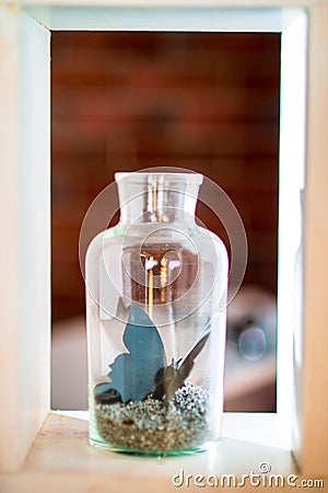 Glass bottle inside which is a decorative butterfly Stock Photo