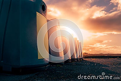Glass bottle recycling facility at sunrise.Raw of plastic containers for glass collection. Warm sunrise time. Sun flare. Nobody Stock Photo