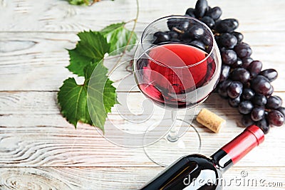 Glass and bottle of red wine with fresh ripe juicy grapes Stock Photo