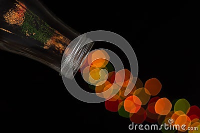 Glass bottle spilling beautiful bokeh Stock Photo