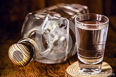 Glass and bottle of strong distilled alcohol, brandy, sugar cane-based drink Stock Photo