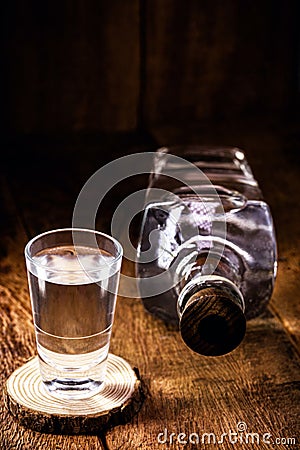 Glass and bottle of strong distilled alcohol, brandy, sugar cane-based drink, distilled alcoholic drink, pure, high alcohol Stock Photo