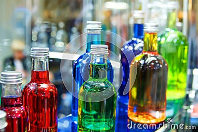 Glass bottles with colorful alcoholic products. Making alcoholic drinks at home. Close-up Stock Photo