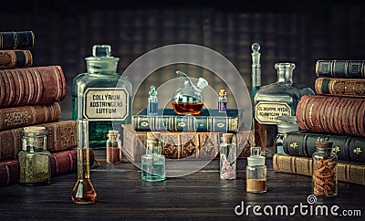 Glass bottles, old books on table of a scientist. Medicine, chemistry, pharmacy, apothecary, alchemy history background. Stock Photo