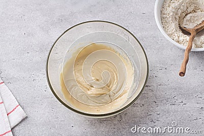 Glass bowl with dough on a gray background. Cooking greek easter orange sesame koulourakia cookies step by step Stock Photo