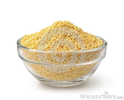Glass bowl of uncooked yellow millet grains Stock Photo