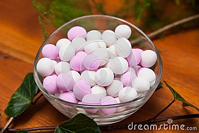 Glass bowl with white and pink sugared almonds Stock Photo