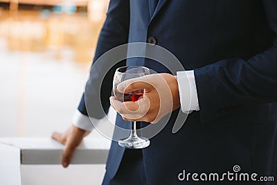 A glass of brandy in the hands of the groom Stock Photo