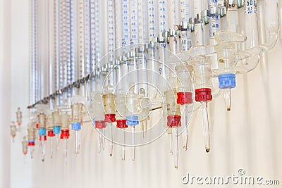 Glass burettes hanging at laboratory wall Stock Photo