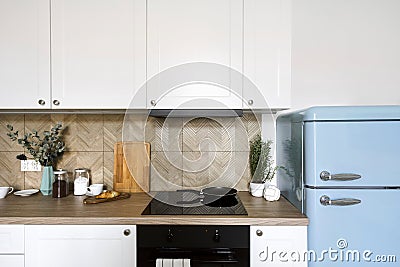 Glass ceramic hob with frying pan in kitchen with cozy interior Stock Photo