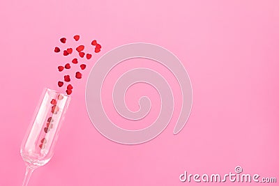 Glass of champagne with red hearts on a pink background. Valentines background, love, date concept with copy space, flatlay Stock Photo