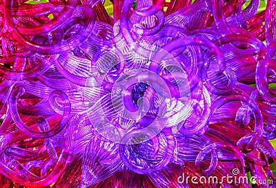 Glass chandelier with curls and red-purple glow Stock Photo