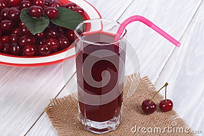 Glass of cherry juice and plenty of ripe cherries Stock Photo