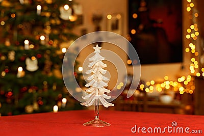 Glass Christmas Tree Table Decoration in Front of Christmassy illuminated Room Stock Photo