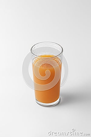 Glass with citrus juice of orange color isolated on a white and gray background with natural shadow Stock Photo