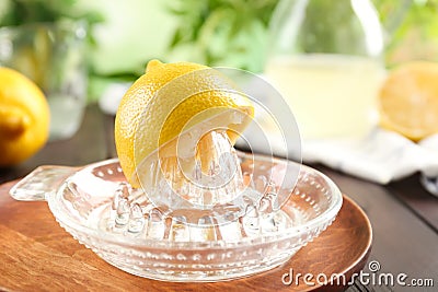 Glass citrus squeezer with lemon half on plate Stock Photo