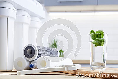 A glass of clean water with osmosis filter and cartridges a kitchen interior. Concept Household filtration system Stock Photo