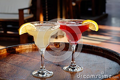 A glass of cocktail at the bar. Two sweet cocktails Cosmopolitan and Margarita in the pub. Mixed alcoholic drinks. Beach party Stock Photo