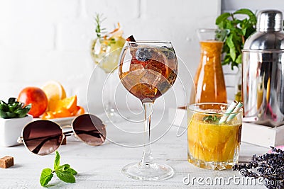 A glass of cocktail with cinnamon, berries and brown sugar and a glass with an orange cocktail or fresh and tonic Stock Photo