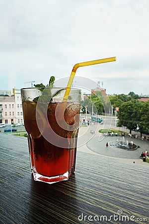 A glass with a cocktail on a table with a panorama overlooking the city. Stock Photo