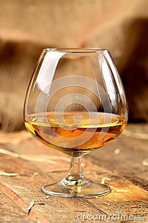 Glass of cognac on rustical wooden background Stock Photo