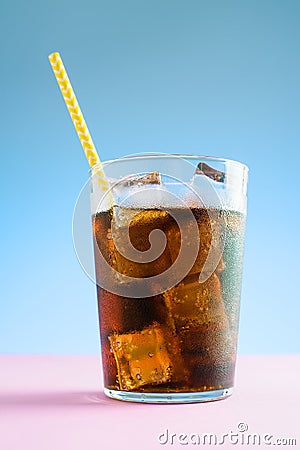 A glass of cola with ice on blue and pink background Stock Photo