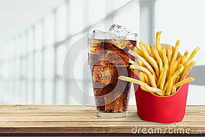 Glass of cola with ice cubes and fries isolated on Stock Photo