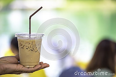 Glass of cold espresso coffee in hand Background blurry views Stock Photo
