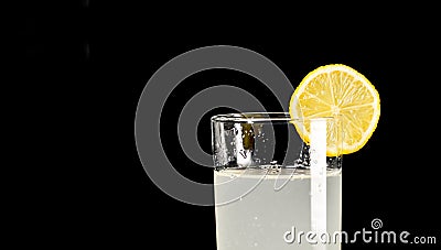 A glass of cold lemonade with a piece of yellow lemon Stock Photo