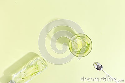 Glass cup with cucumber water on a light green background. Minimalistic creative concept. Copy space Stock Photo