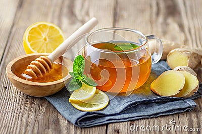 A glass cup of tea with lemon, mint, ginger and honey Stock Photo