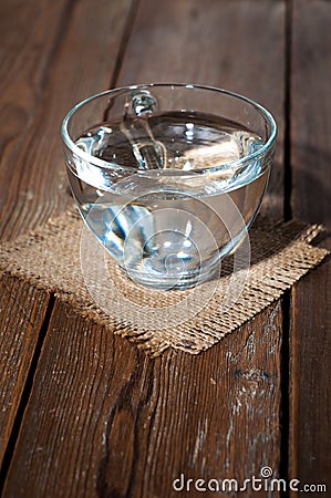 Glass cup with water on a background of burlap Stock Photo