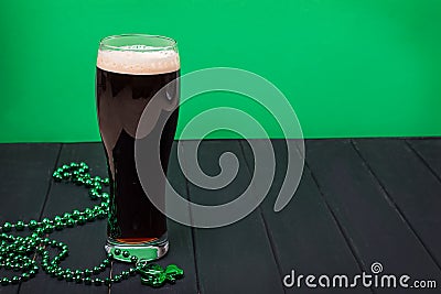 Glass of dark stout beer and traditional clover shaped decor Stock Photo