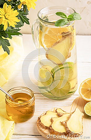 Glass decanter with water, infused with lemon, lime, ginger and ingredients on light background. Stock Photo