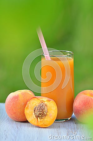 Glass of delicious peach juice and peaches on table Stock Photo
