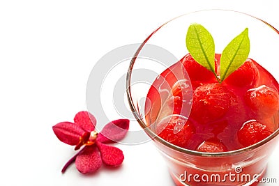 Glass delicious refreshing drink of vibrant watermelon with red orchid on white background Stock Photo