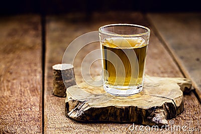 Glass of distilled alcoholic beverage on wooden background with copy space for text. Call for rum or cachaÃ§a Stock Photo