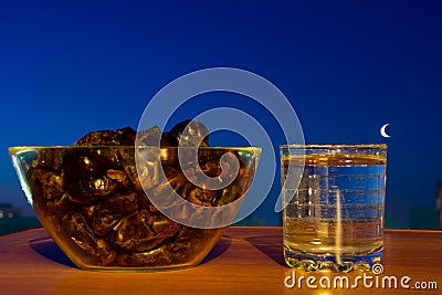 Glass of drinking water, dates and moon . Basic food and drink to break Ramadan fast. Stock Photo